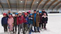 Grupa uczniów z opiekunami na lodowisku